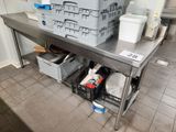 a large stainless steel table with a bunch of containers on it