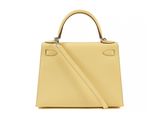 a yellow leather handbag with a strap and handle