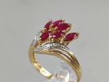 a close up of a gold ring with red stones on it