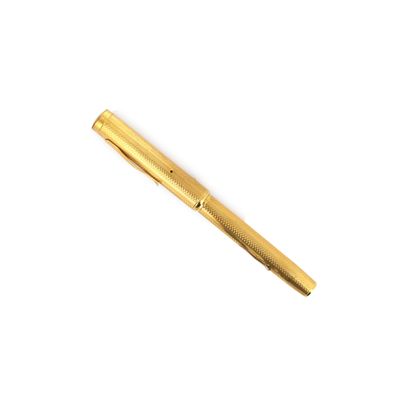 un stylo de couleur dorée posé sur une surface blanche
