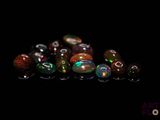 plusieurs perles de verre de différentes couleurs posées sur une surface noire