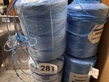 several rolls of blue yarn are in a box on the floor