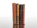 several old books are stacked on top of each other on a table