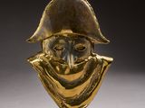 a gold statue of a man wearing a hat and scarf
