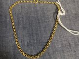 un bracelet en chaîne d'or avec des perles noires et un cordon blanc
