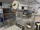 a machine that has a roll of paper on the conveyor belt
