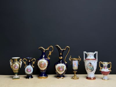 de nombreux vases de formes variées posés sur une table, sur fond noir