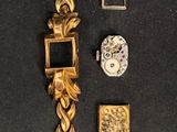 a gold watch with a chain around it on a black surface