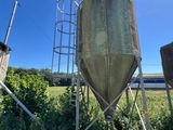 a large metal tank sitting in the middle of a field