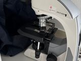 un microscope et un flacon de liquide posés sur une table