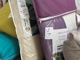 many pillows and bags on a table in a store