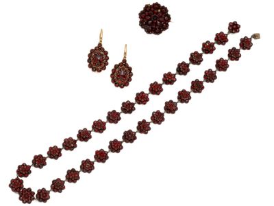 un gros plan d'un collier et de boucles d'oreilles sur fond blanc