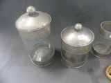 a silver container with a lid and a spoon next to it