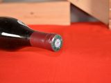 a bottle of wine sitting on a table next to a wooden crate