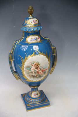 a blue vase with a painting on it sitting on a table