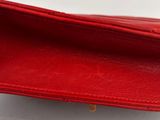 the inside of a red leather wallet with a gold clasp