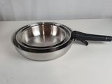 a close up of a metal pan with a handle on a table