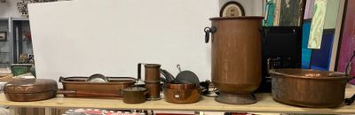 de nombreuses casseroles et poêles rangées sur une étagère dans une pièce
