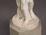marble statue of a woman holding a child on a pedestal