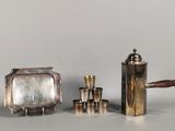 a silver tea pot and a silver tea set on a table