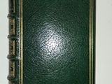 a green book with gold trim on a white table