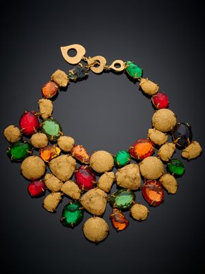 un gros plan d'un collier coloré posé sur une surface noire