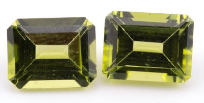 une paire de tourmalines vertes et jaunes sur un fond blanc