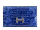 a blue leather clutch bag with a metal h on the front