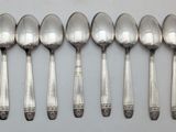six silver spoons are lined up in a row on a table