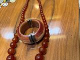 a wooden table with a bracelet and a necklace on it