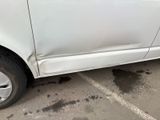 a white car that has a dent in the side of it