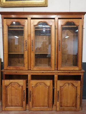 an image of a wooden cabinet with glass doors and a painting on the wall