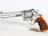 a close up of a revolver with a wooden handle on a white background