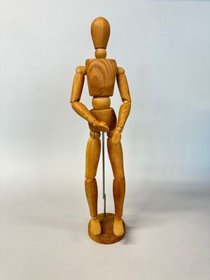 un mannequin en bois posé sur un socle