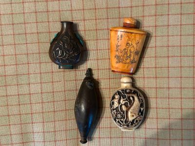 trois vases et une bouteille posés sur une table