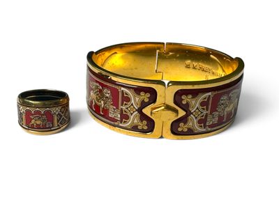 un bracelet doré et rouge et une bague posés sur un fond blanc