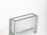 un bloc de verre transparent posé sur une surface blanche