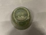 a glass jar with a green substance inside of it
