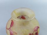a glass vase with pink flowers on it on a white surface