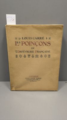 un vieux livre posé sur une table à côté d'un mur