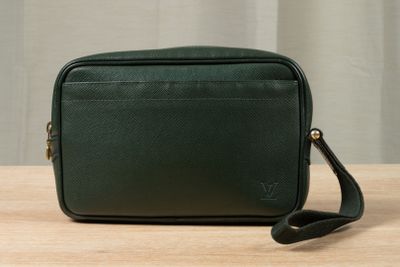 a green cross body bag sitting on top of a wooden table