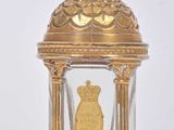 a gold clock with a glass dome on top of it