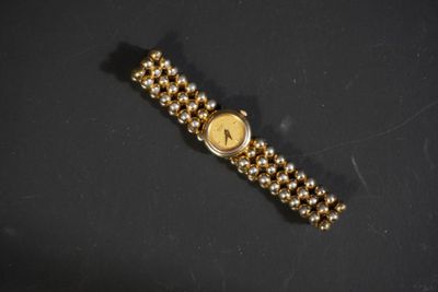 gros plan d'une montre en or sur une surface noire