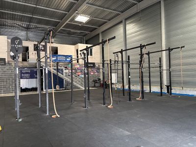 un espace de musculation avec une barre de traction au milieu de la salle
