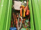 a green trash can filled with tools and other things