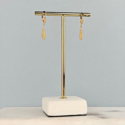 un gros plan sur une paire de boucles d'oreilles posées sur un présentoir sur une table