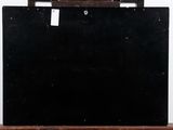 a black piece of luggage sitting on top of a wooden table