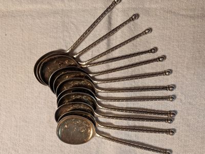 Plusieurs cuillères et fourchettes sont alignées sur une table