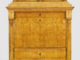 une commode en bois surmontée de trois tiroirs