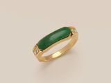 a close up of a gold ring with a green stone